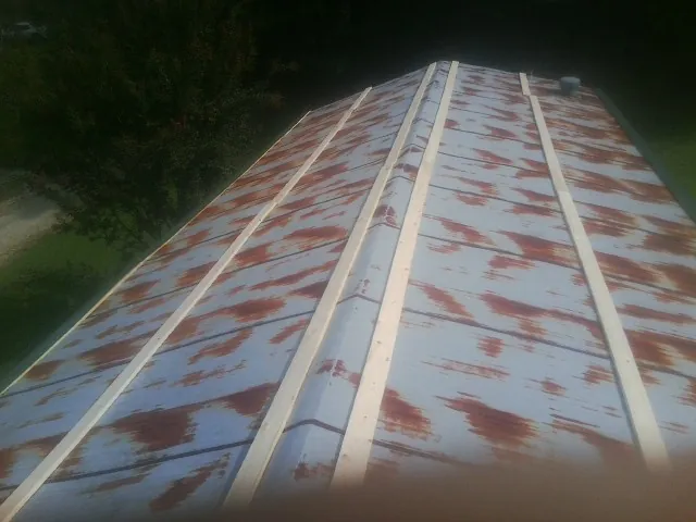 Rusted metal roof panels with new wood purlins before replacement — Storm Damage Roof Repair in Vian by Roofing Brothers
